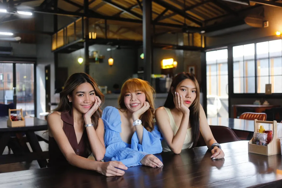 เพื่อนสามคนที่โต๊ะไม้ตัวยาว