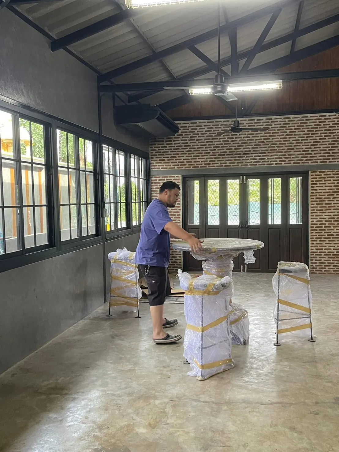 คนหนึ่งกำลังจัดโต๊ะและเก้าอี้ภายในบ้านของบาราสต้า ชิลล์ เฮาส์
